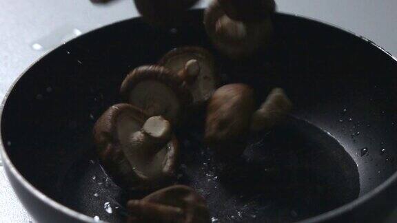 用慢动作将蘑菇倒入锅中