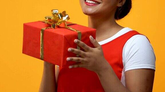 快乐的年轻女子牵着礼物的手场合礼物周年惊喜