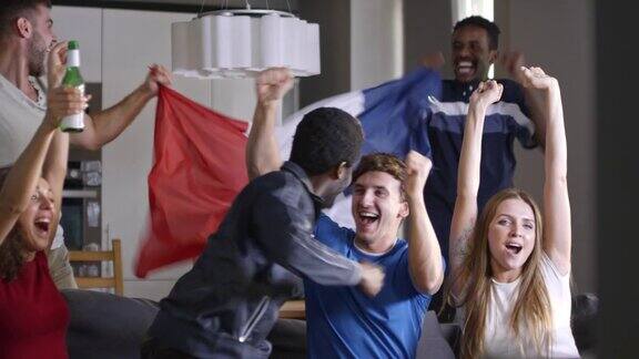 手持法国国旗观看电视比赛的体育迷
