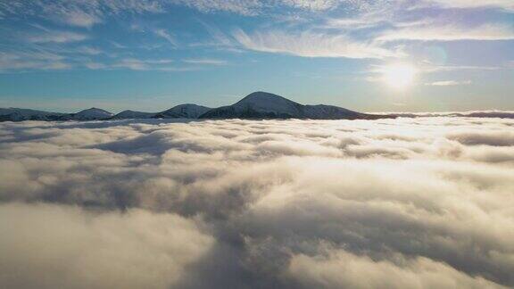 从空中俯瞰充满活力的日出在白色浓密的云层上远处的深色山脉在地平线上