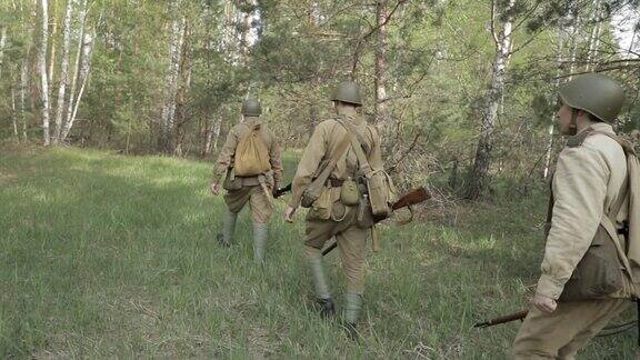 俄罗斯苏联步兵红军士兵在夏季沿着森林路行走一群士兵在森林中行进