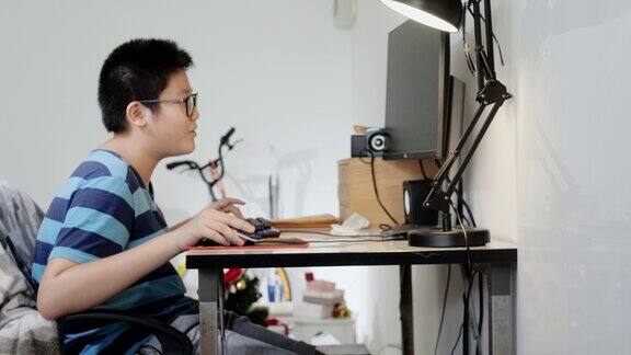 快乐的亚洲玩家男孩戴着防护眼镜在家玩网络游戏生活理念