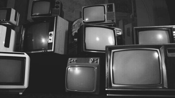 复古电视在许多电视中间打开绿色屏幕黑白色调