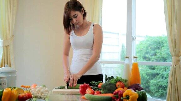 快乐女人烹饪蔬菜绿色沙拉