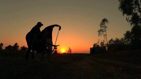 老人用手杖和他的女儿在夕阳下散步慢镜头