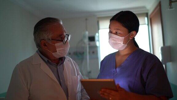 医疗工作者在医院使用数字平板电脑和口罩