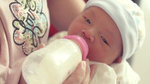 母亲用奶瓶喂养新生儿