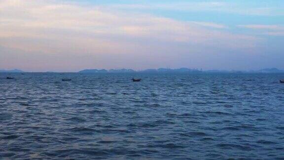 华欣泰海黄昏时分海浪和当地码头上的小船