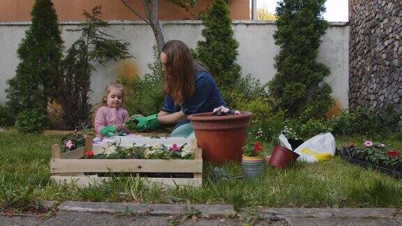 小女孩一边学习园艺一边帮妈妈种花