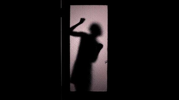 惊恐的女人侧影敲着玻璃门检查门把手恐惧逃跑