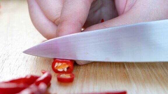 妇女在厨房的一块木板上切红辣椒准备准备食物