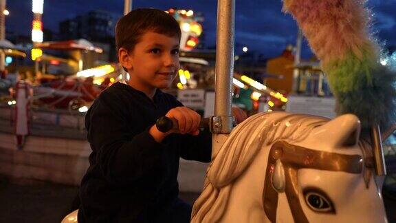 可爱的小男孩在游乐场骑旋转木马