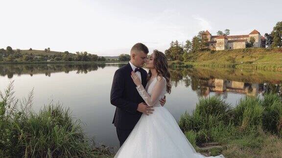 白种新郎和新娘在湖边的公园里婚礼的夫妇新婚夫妇