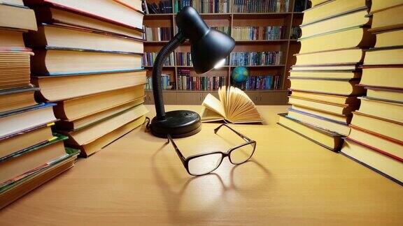 书在图书馆的桌子上在灯和眼镜风翻页书架和地球仪的背景