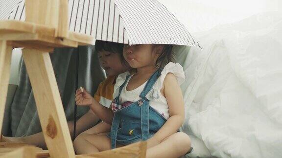泰国男婴和女婴在卧室的伞下偷窥