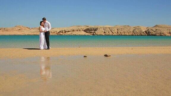 一对新婚夫妇在埃及的海滩上散步异国情调的蜜月