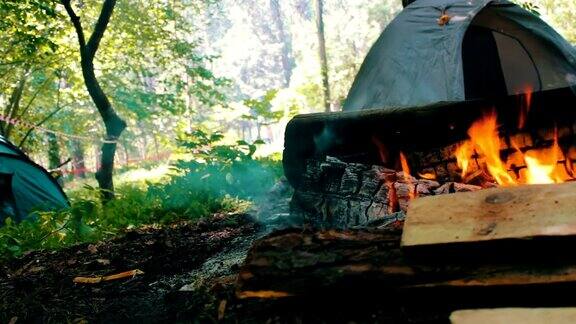 在旅游帐篷的背景中燃烧着的火和木头