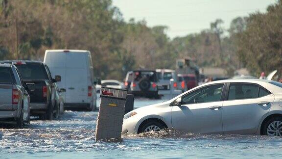 佛罗里达州居民区的美国街道被移动的车辆淹没周围都是水伊恩飓风自然灾害的后果