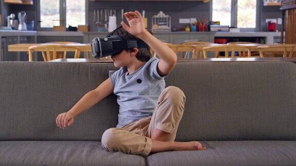 坐在沙发上戴着虚拟现实耳机的男孩