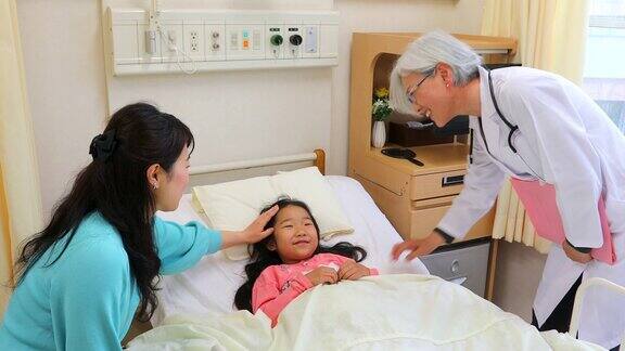 女医生在病床上对生病的孩子说话