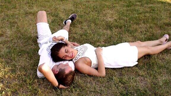 一对美丽的夫妇躺在公园的草地上