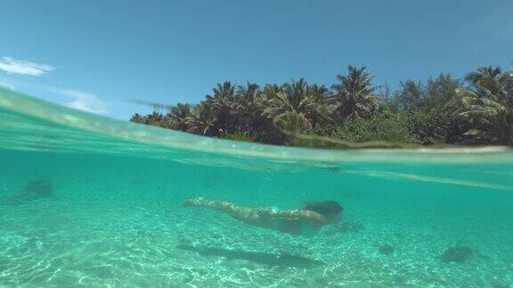半水下:年轻女子潜水在闪烁的绿松石海水
