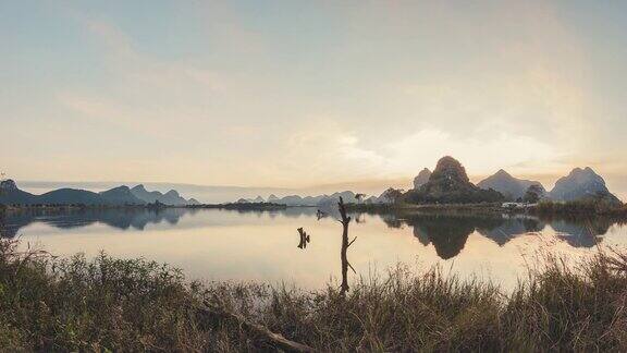 在中国广西柳州4K延时镜头反射黄昏时的湖泊和山丘