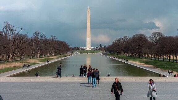 4K时间推移的华盛顿纪念碑是一个方尖碑在国家广场反射池和游客在华盛顿特区美国建筑和吸引力
