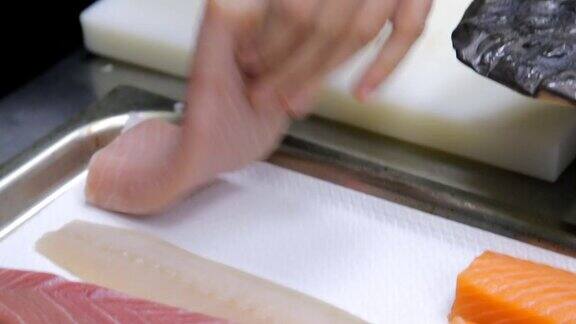 厨师正在为寿司切金枪鱼片