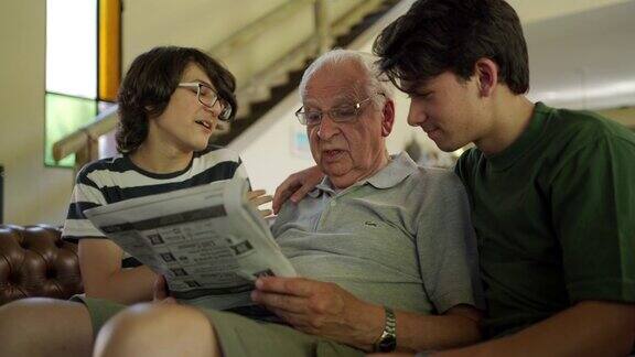 爷爷和孙子们在看报纸