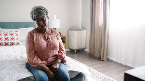 一位患有抑郁症的老年妇女坐在卧室里用慢动作拍摄