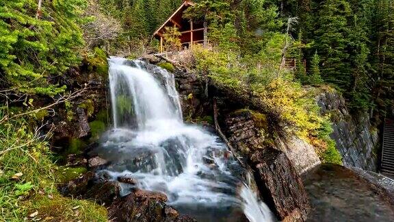 班夫国家公园艾格尼丝湖的秋天森林里瀑布流淌着木制茶室