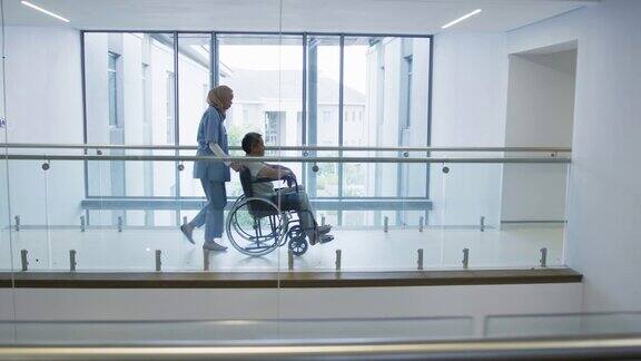 年轻医生推着轮椅在医院的病人在4k