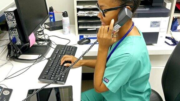 年轻的非裔美国护士在护士站接听电话