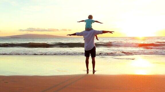 父亲和儿子在日落时分的海滩上一起玩飞机手臂游戏