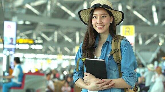 在候机楼的年轻女人的肖像年轻妇女独自乘飞机旅行