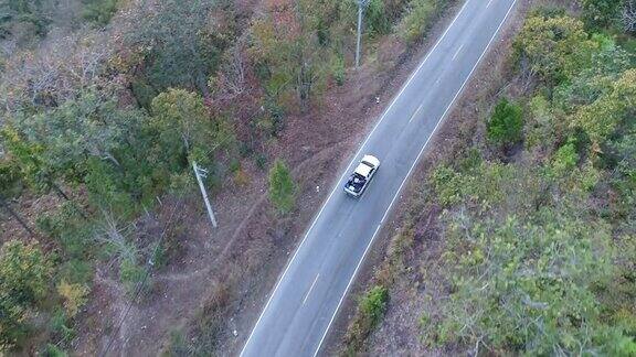 空中拍摄汽车驾驶通过森林道路