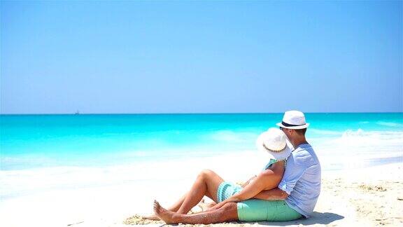 一对年轻夫妇在白色的海滩上度过暑假幸福的情侣享受他们的蜜月