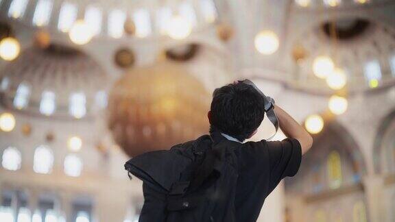 年轻的男游客在清真寺内拍照