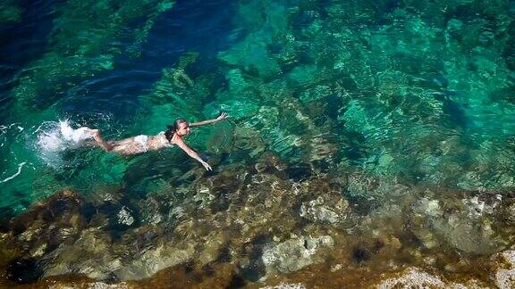 一名年轻女子在塞浦路斯蔚蓝的大海中游泳