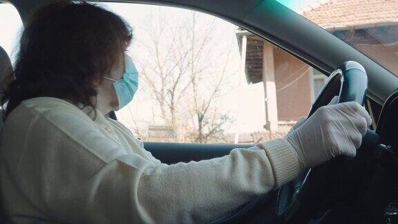 活跃的老年妇女开车去上班驾驶时戴上防护口罩和防护手套疾病预防