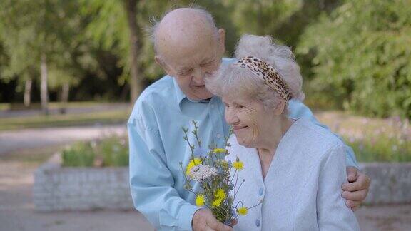一位老人送给他的爱人一束简单的野花他拥抱她亲吻她