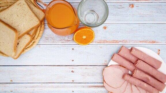 早餐食物意大利香肠沙拉黄瓜面包和果汁出现在桌子上-停止运动