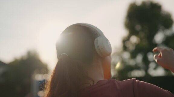 女人背后戴上耳机听音乐