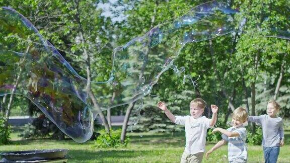 一名男子在城市公园为儿童表演时吹巨大的肥皂泡
