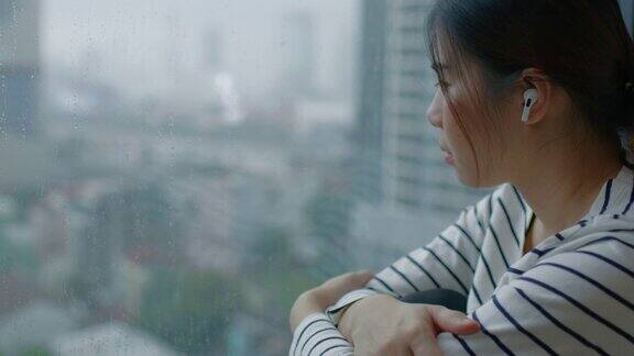 悲伤的女人看着外面下雨的天气