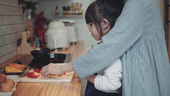 可爱的小女孩在家和妈妈一起做饭