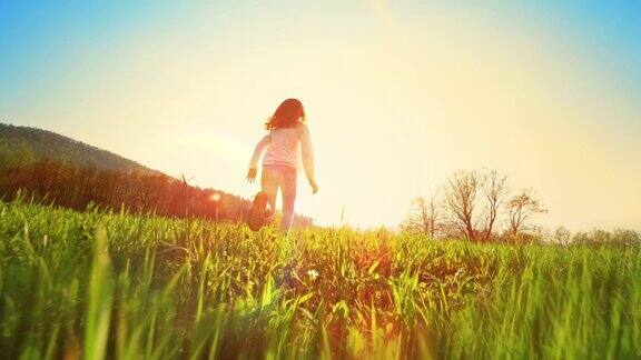 SLOMOTS女孩在午后的阳光下在草地上奔跑