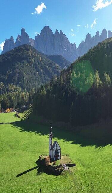 阳光明媚的日子意大利阿尔卑斯山Dolomites美丽的圣乔凡尼圣约翰教堂的航拍视频
