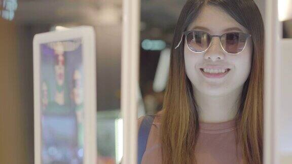一名亚洲女性在商店选购太阳镜的4k视频场景